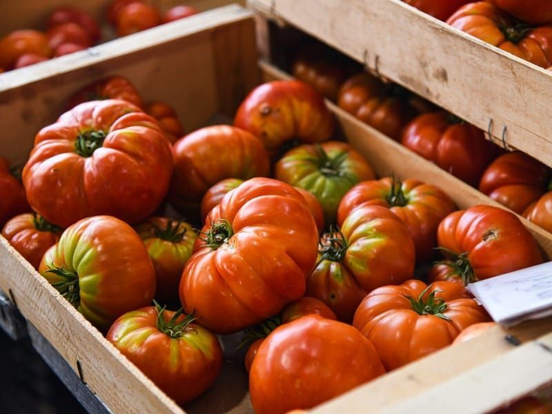 Heirloom tomatoes in wooden crates at a market